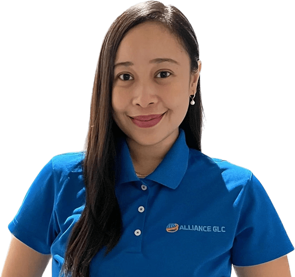 A woman in blue shirt standing next to green wall.