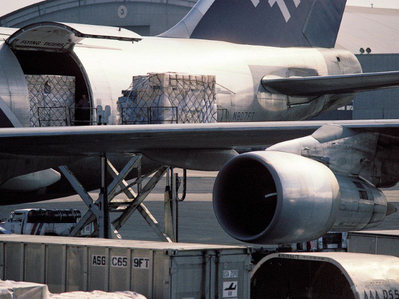 A large airplane parked at an airport loading dock.