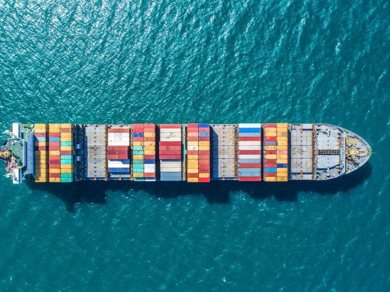 A large cargo ship in the ocean with many containers.