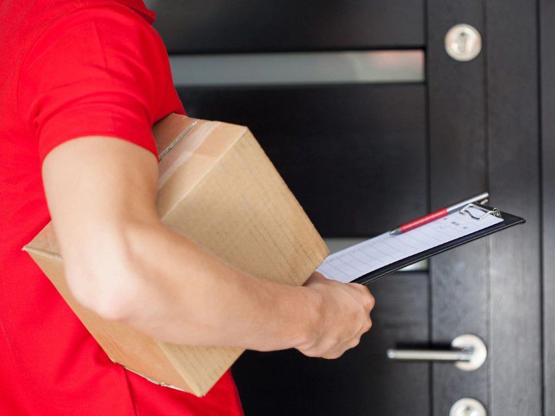 A person holding a box and a clipboard