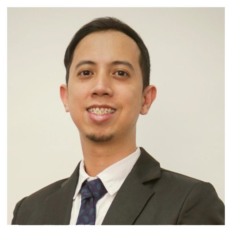 A man in a suit and tie smiling for the camera.