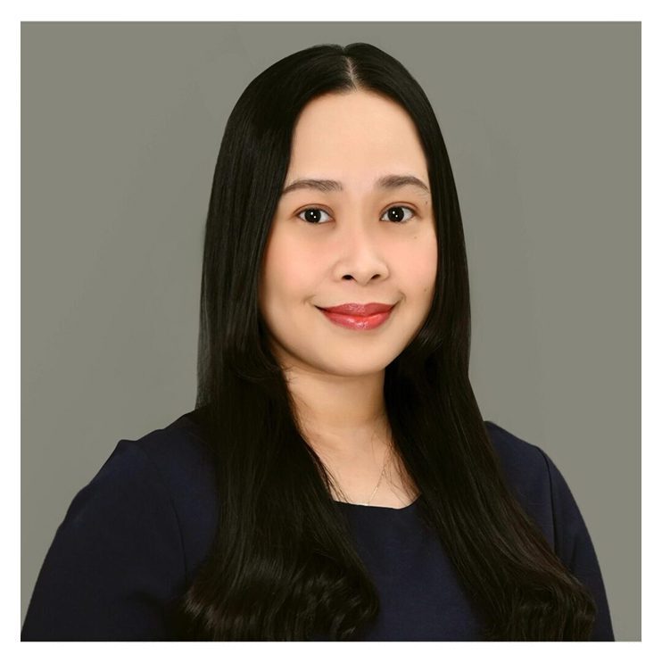 A woman with long black hair wearing a blue shirt.