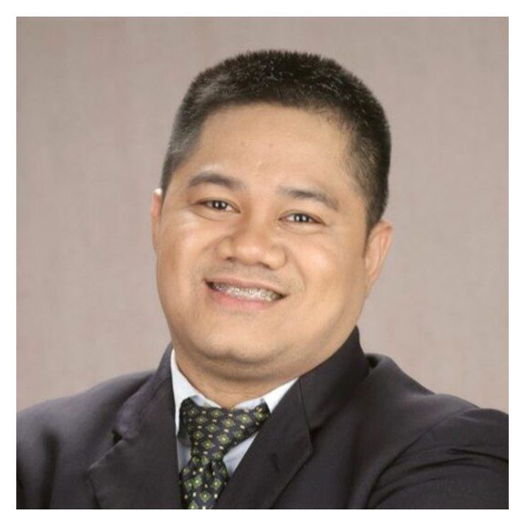 A man in suit and tie smiling for the camera.