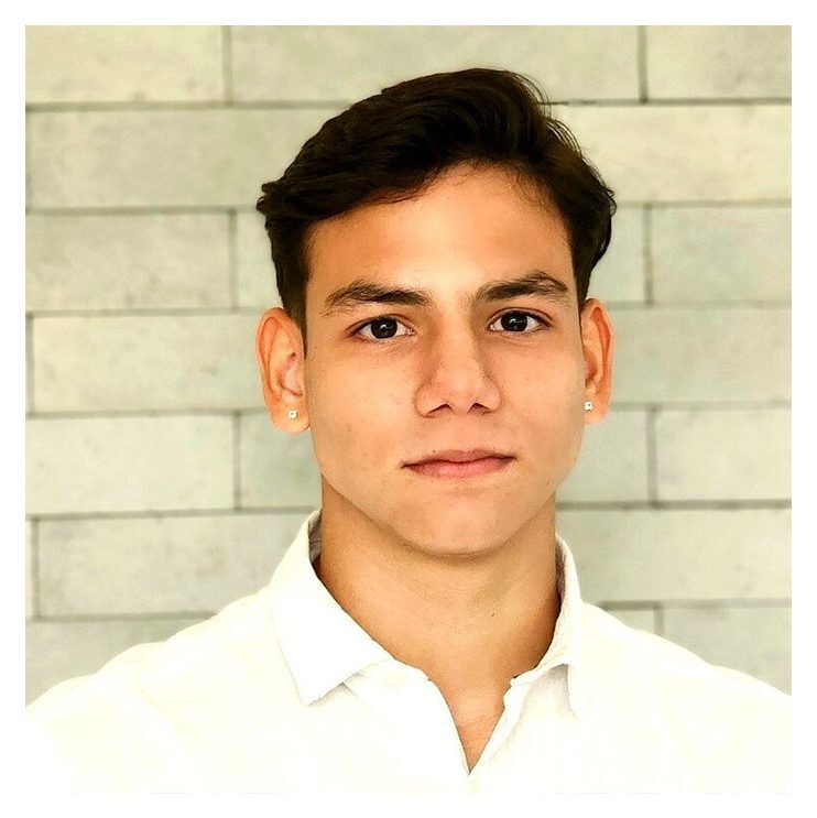 A young man in white shirt and brick wall