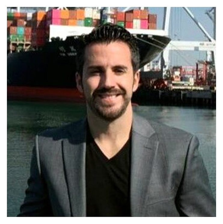 A man in a suit standing next to a boat.