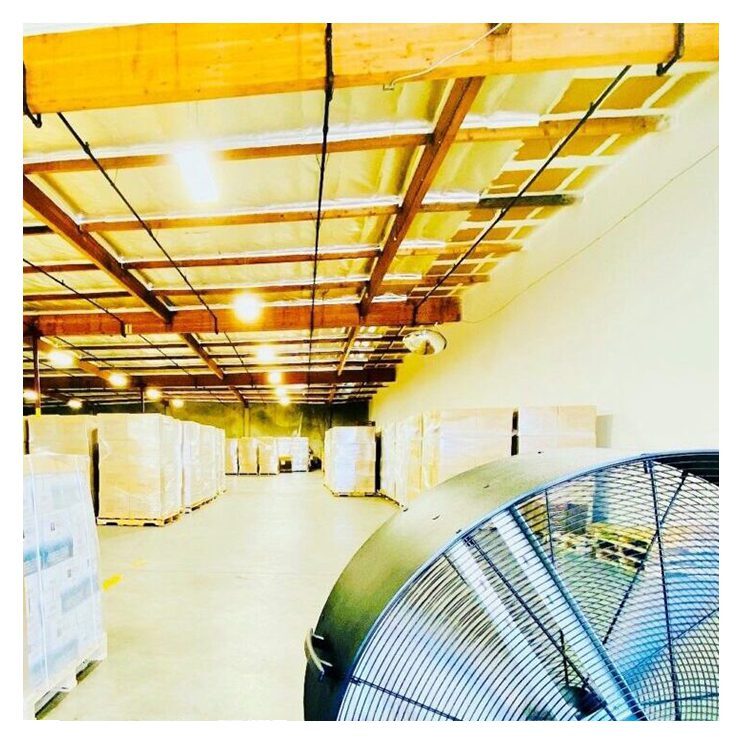 A warehouse with many boxes and fans in it