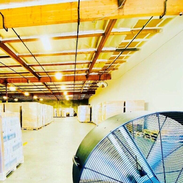A warehouse with many boxes and fans in it