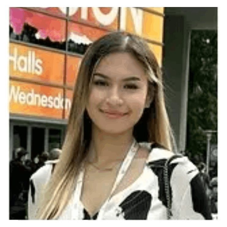 A woman standing in front of an orange building.